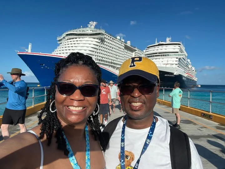 John and Veronica smiling together with cruise ships behind them
