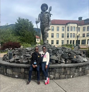 John and Veronica posing beside a large outdoor statue