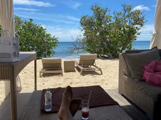 A peaceful beach view from a shaded resort terrace