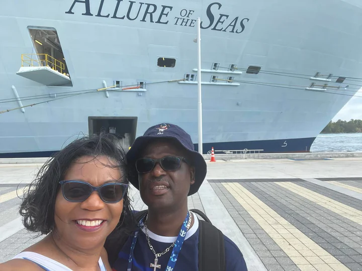 John and Veronica smiling in front of the Allure of the Seas