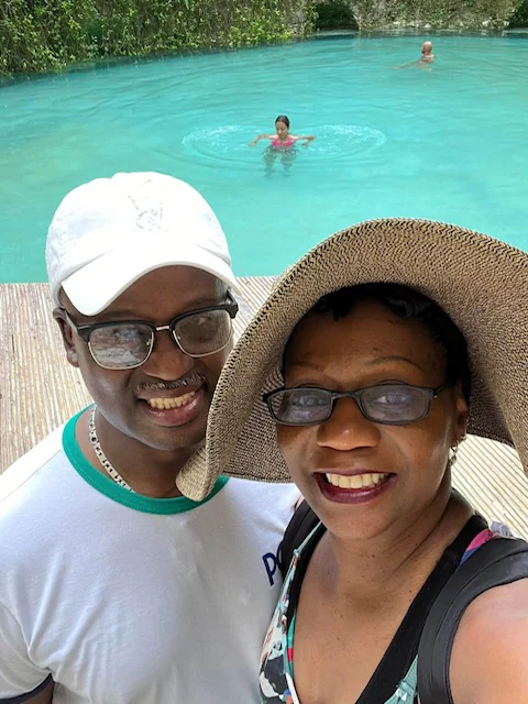 John and Veronica smiling together by turquoise water