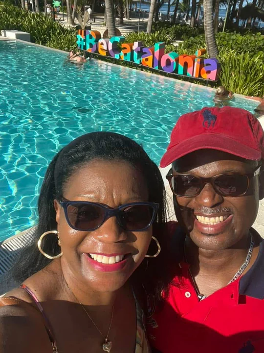 John and Veronica smiling together beside a resort pool